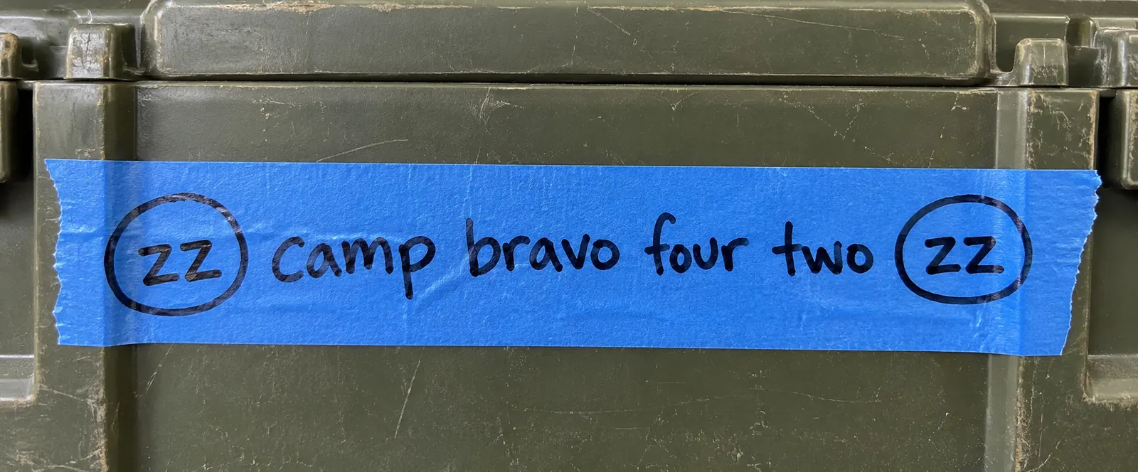 Close-up of blue tape reading (zz) camp bravo four two (zz).
